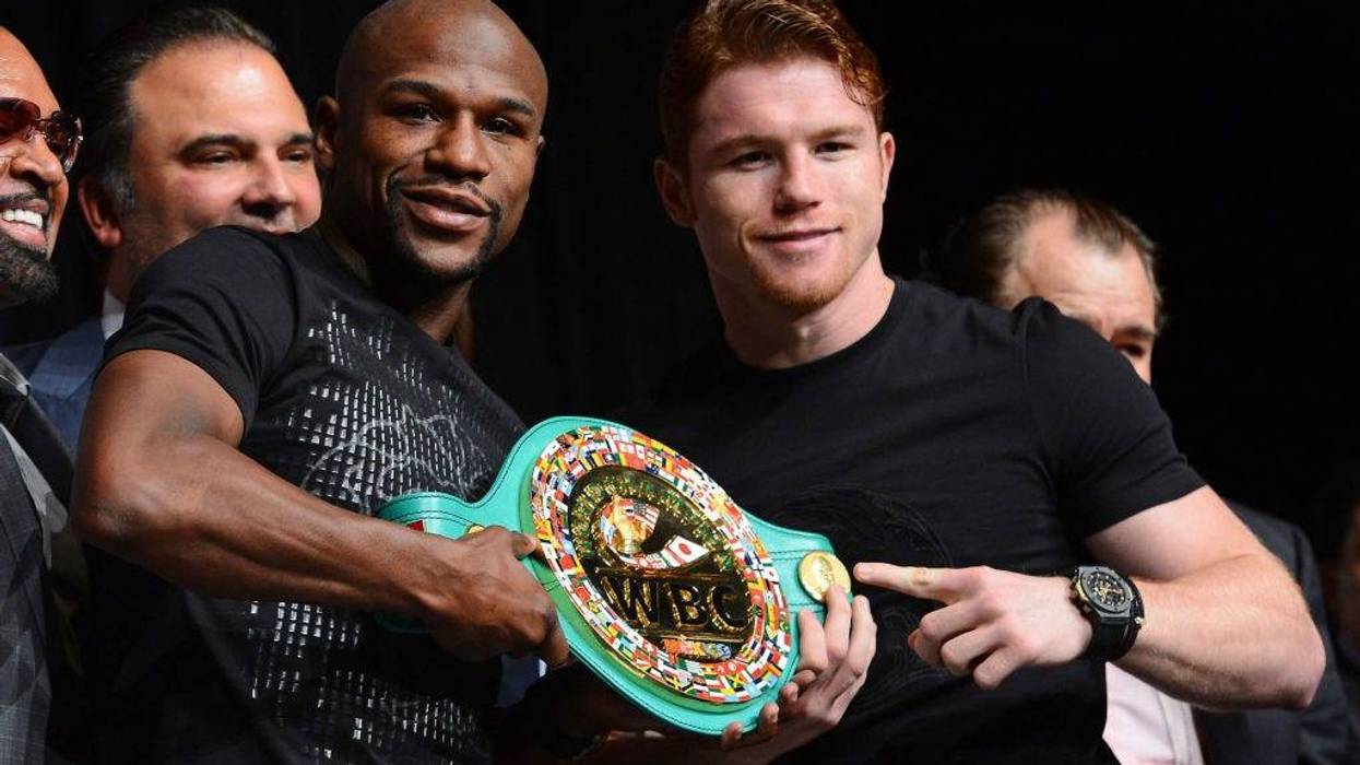 Boxers Floyd Mayweather Jr. (L) and Canelo Alvarez hold a WBC super welterweight championship belt during the final news conference for their bout at the MGM Grand Hotel/Casino on September 11, 2013 in Las Vegas, Nevada.