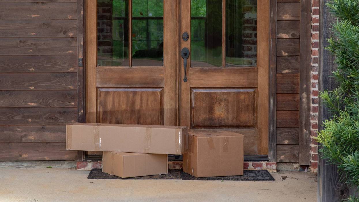 Boxes of postal service items sitting next to door of suburban house
