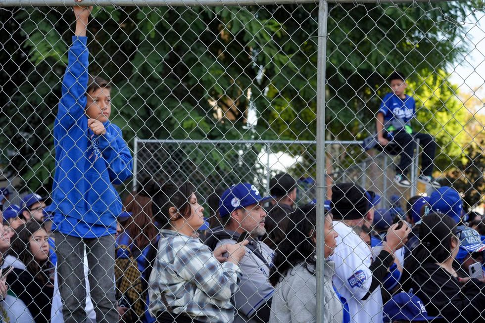 boy hanging on fence