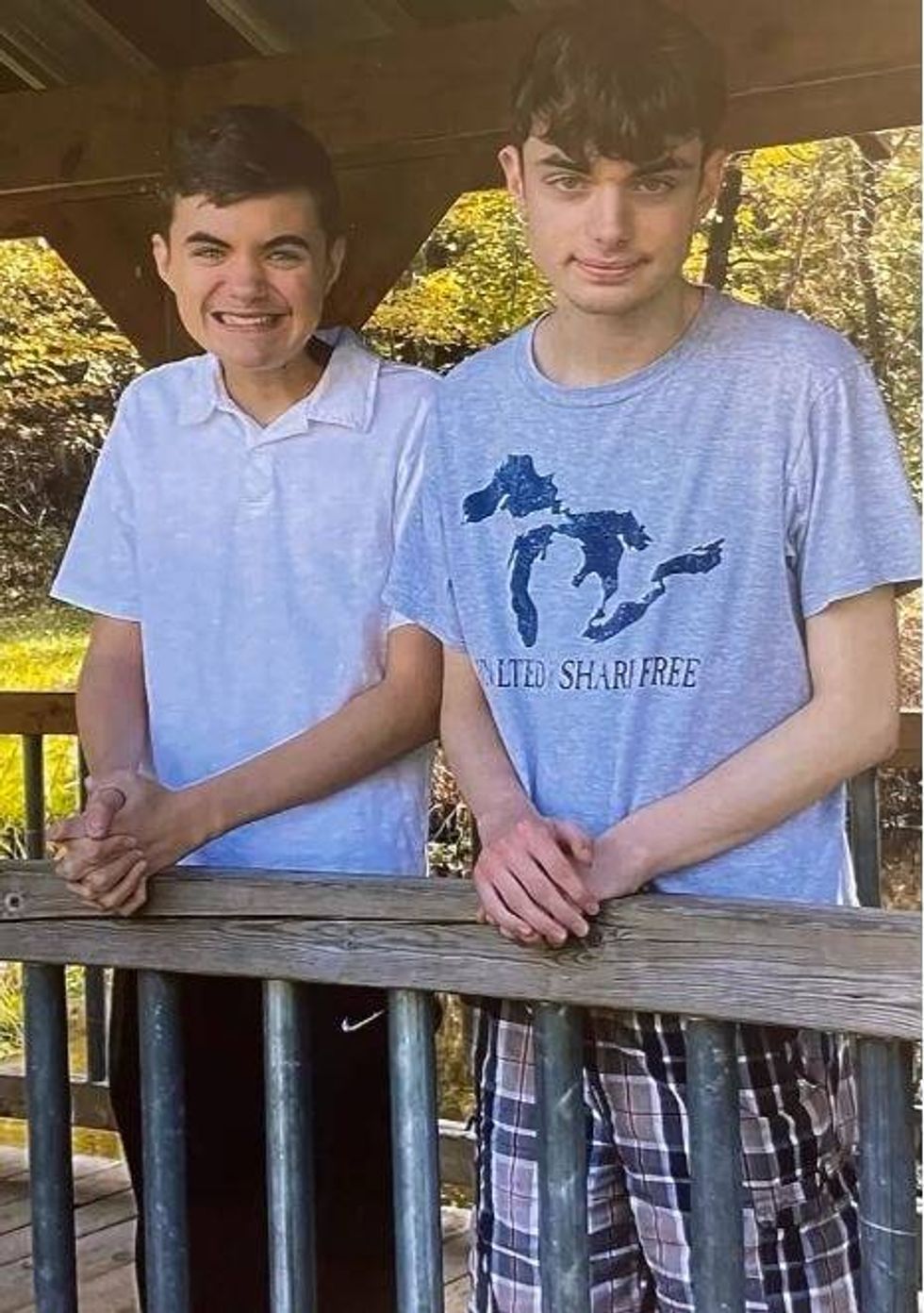 Brandon and Noah Cirigliano standing on what appears to be a covered bridge in a park.