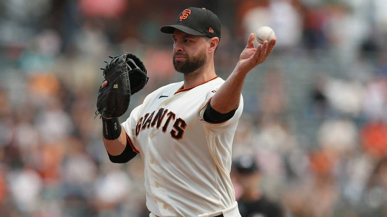 Brandon Belt #9 of the San Francisco Giants throws the ball to pitcher Anthony DeSclafani #26 covering first to get the out of Dominic Smith #2 of the New York Mets in the top of the second inning at Oracle Park on August 18, 2021 in San Francisco, California.