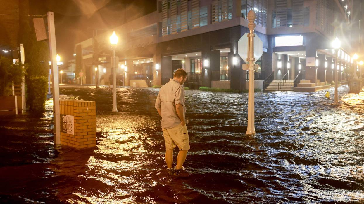 Brandon Marlow walks through surge waters flooding the street after Hurricane Milton came ashore in Fort Myers, Florida.