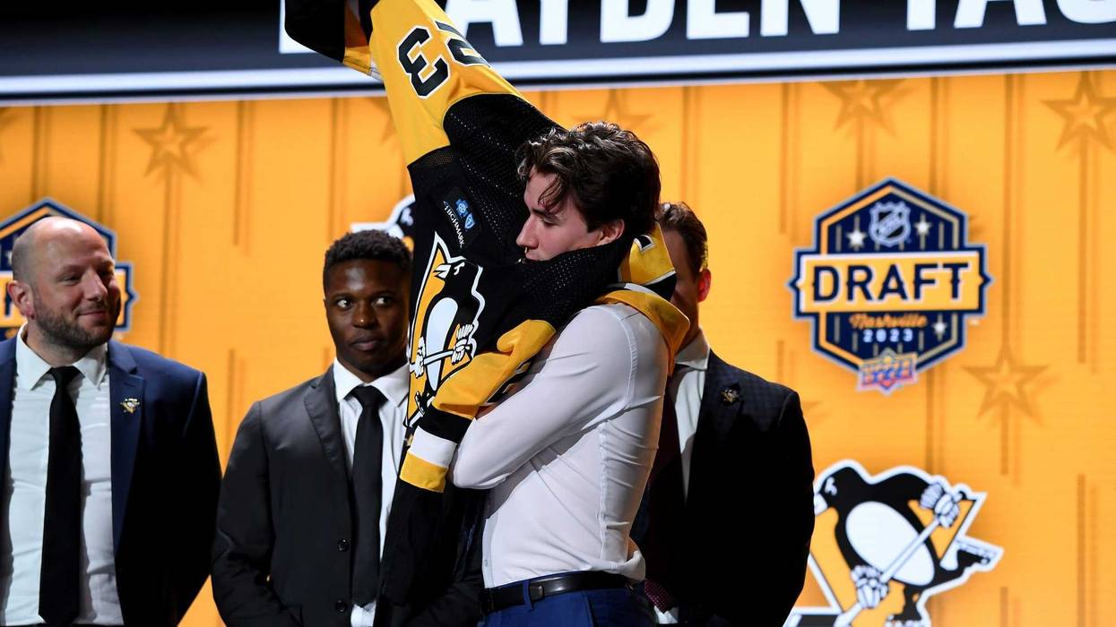 Brayden Yager putting on Pens jersey at draft
