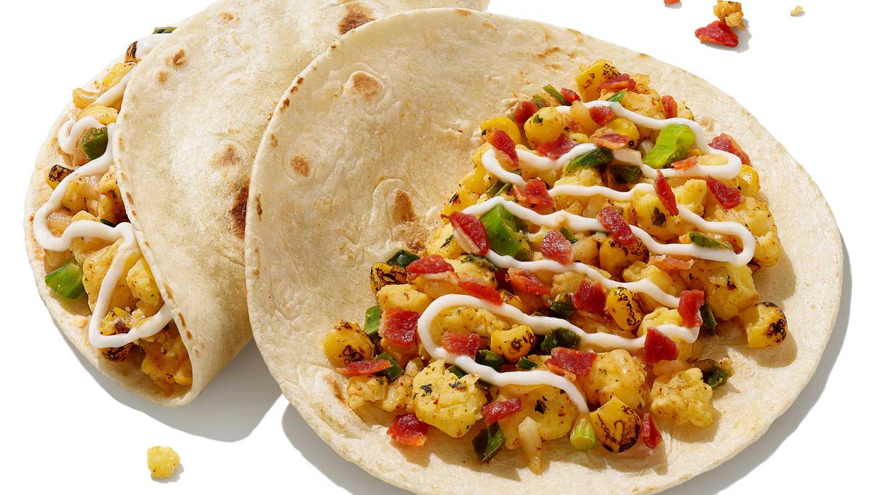 Breakfast tacos from Dunkin'. Open face tacos with crambled eggs, melted sharp white cheddar cheese, fire-roasted corn, and a drizzle of tangy lime crema.