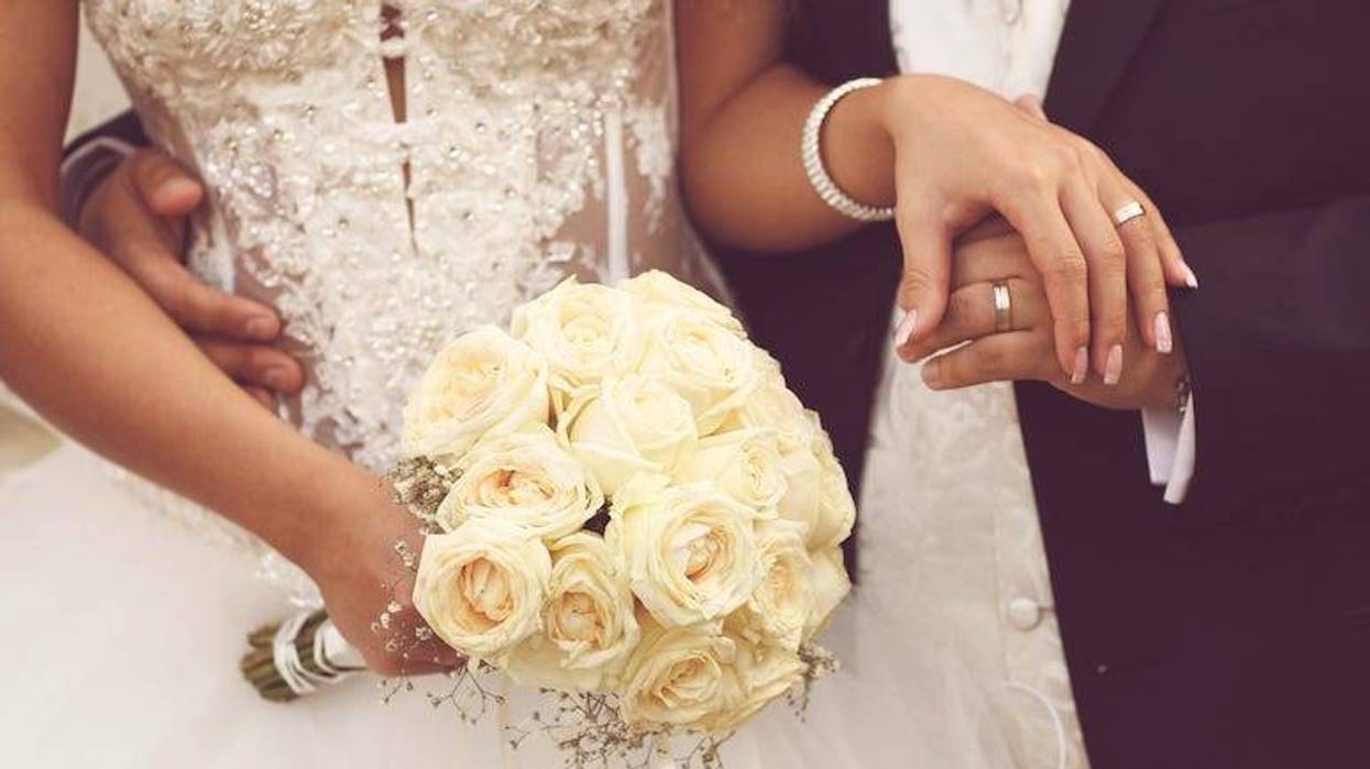 Bride with bouquet and groom holding hands