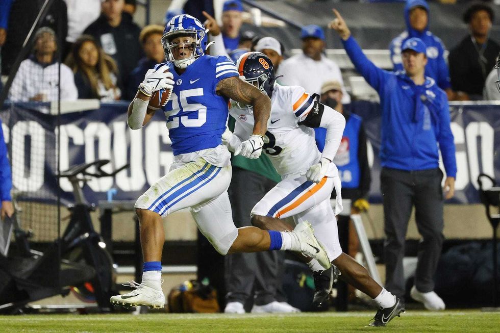 Brigham Young Cougars running back Tyler Allgier (25) runs for a third quarter touchdown against past Virginia Cavaliers cornerback Darrius Bratton (8) at LaVell Edwards Stadium.