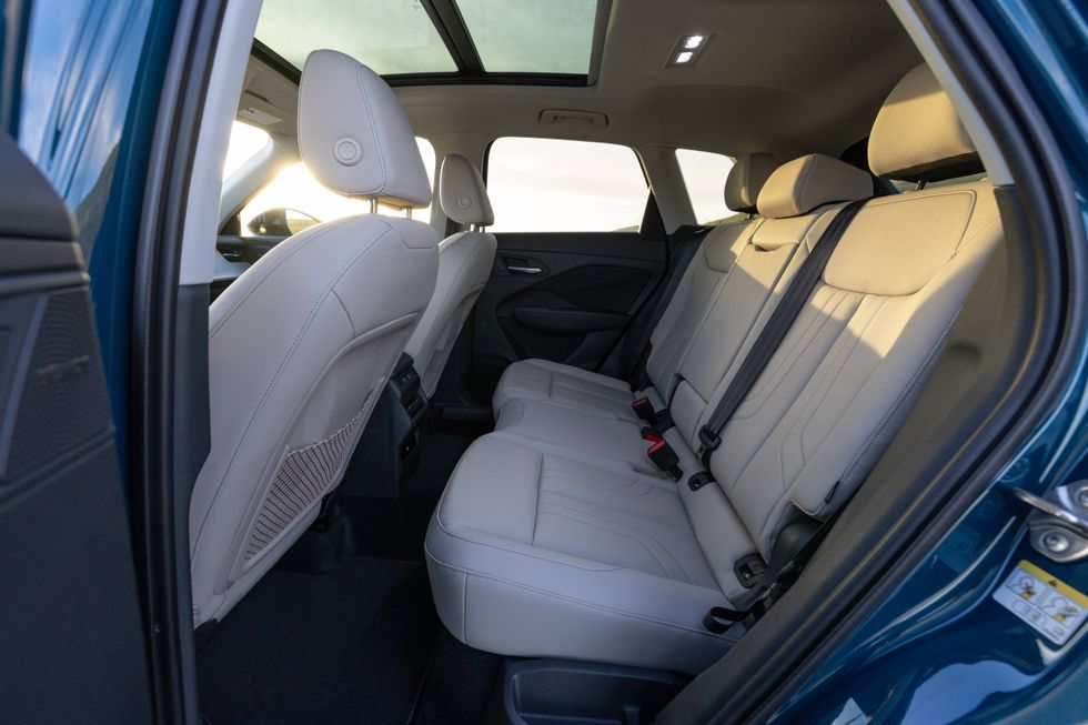 Bright car interior with beige rear seats and panoramic sunroof.