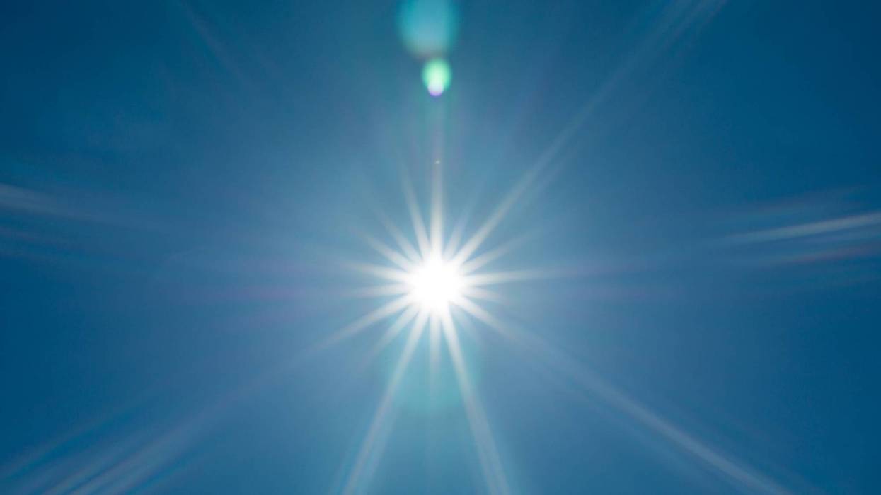 Bright sun rays in clear blue sky.