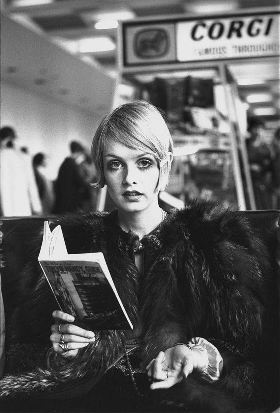 British model Twiggy reading a guide book to Tokyo at London Airport, 1967