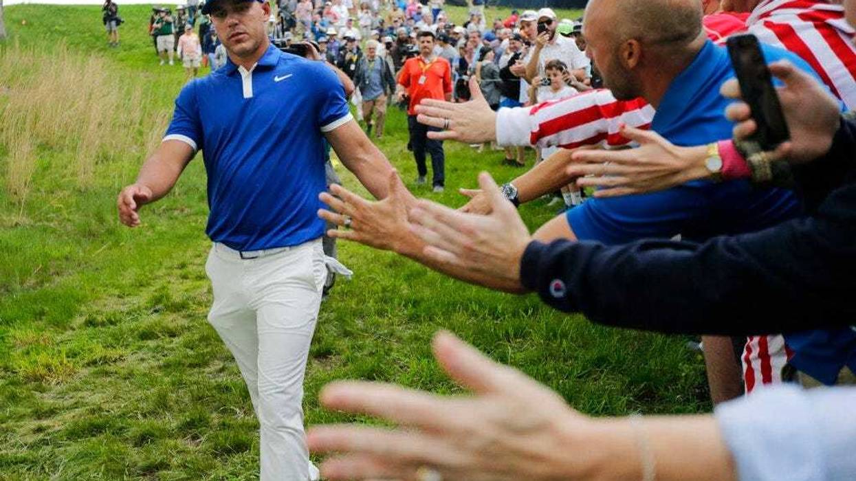 Brooks Koepka greets spectators as he walks down to the 15th tee during the second round of the PGA Championship golf tournament, Friday, May 17, 2019, at Bethpage Black in Farmingdale, N.Y.