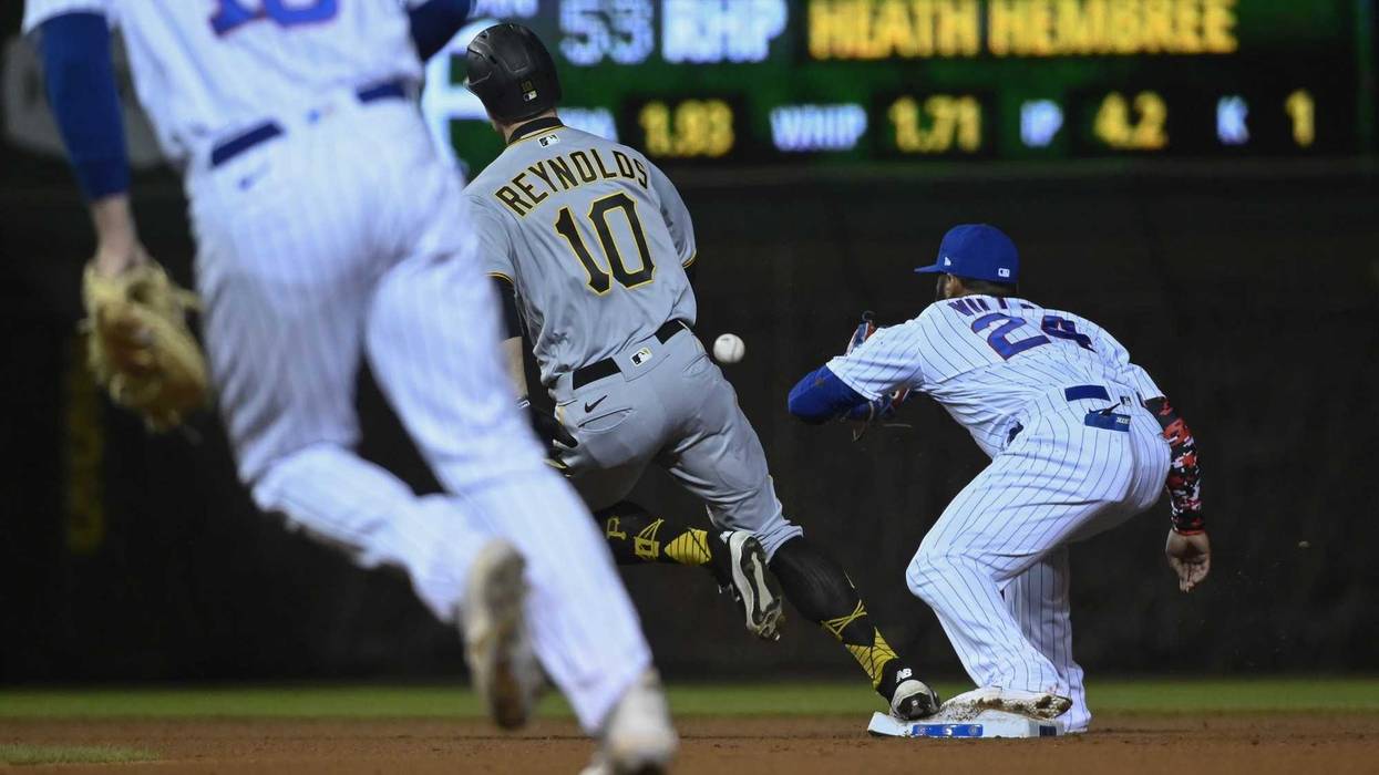 Bryan Reynolds (10) heads to third base as Chicago Cubs second baseman Jonathan Villar (24) gets the ball during the seventh inning at Wrigley Field.