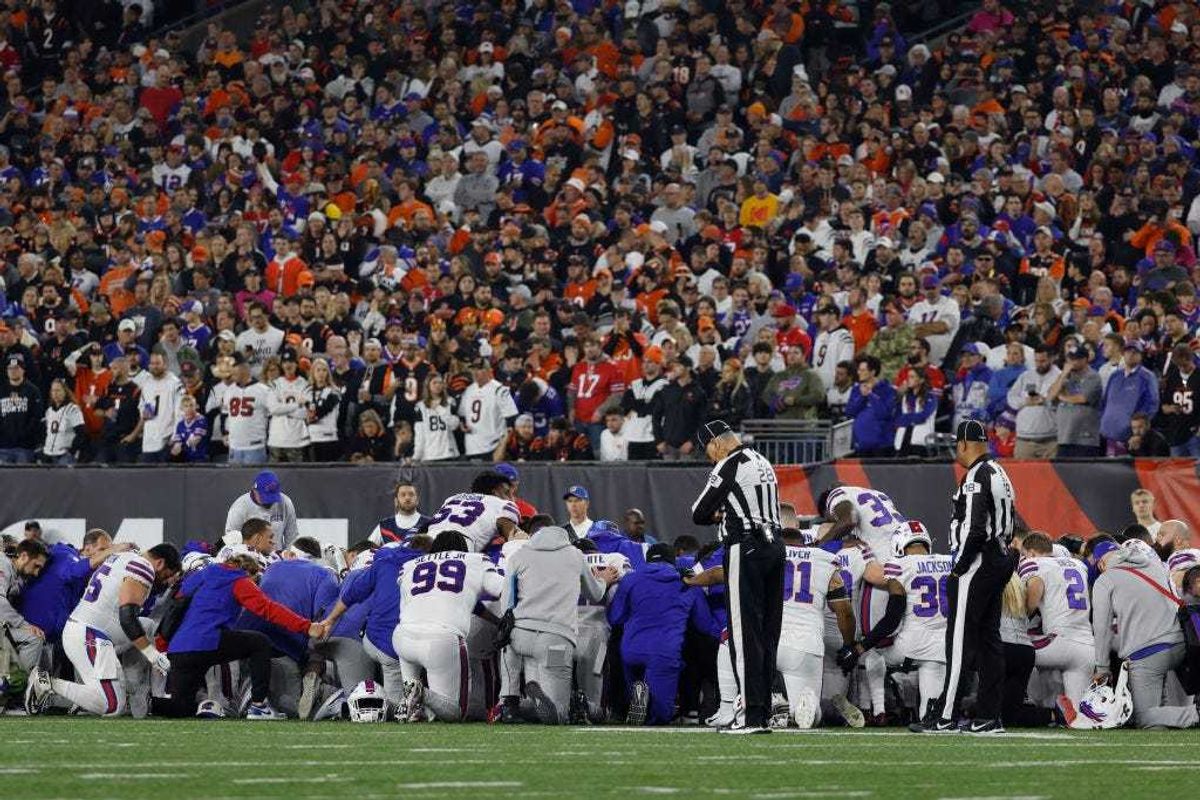Buffalo Bills players huddle after teammate Damar Hamlin #3 collapsed following a tackle against the Cincinnati Bengals during the first quarter at Paycor Stadium on January 02, 2023 in Cincinnati, Ohio.