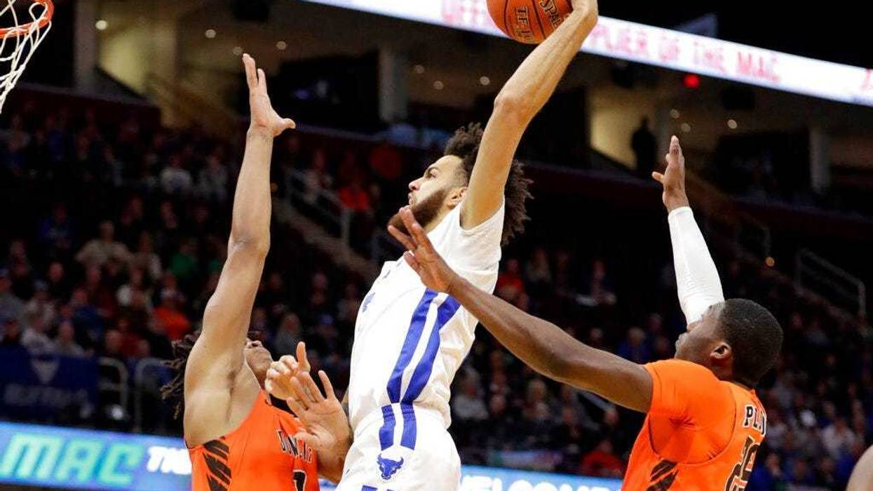 Buffalo's Jeremy Harris, center, drives to the basket against Bowling Green's Demajeo Wiggins, left, and Daeqwon Plowden during the first half of an NCAA college basketball championship game of the Mid-American Conference men's tournament, Saturday, March
