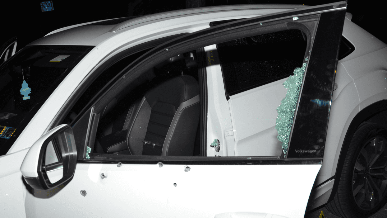 Bullet holes in the side of a car; window completely shattered.