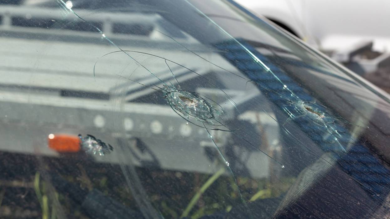 Bullet holes in the windshield of a car stock photo.