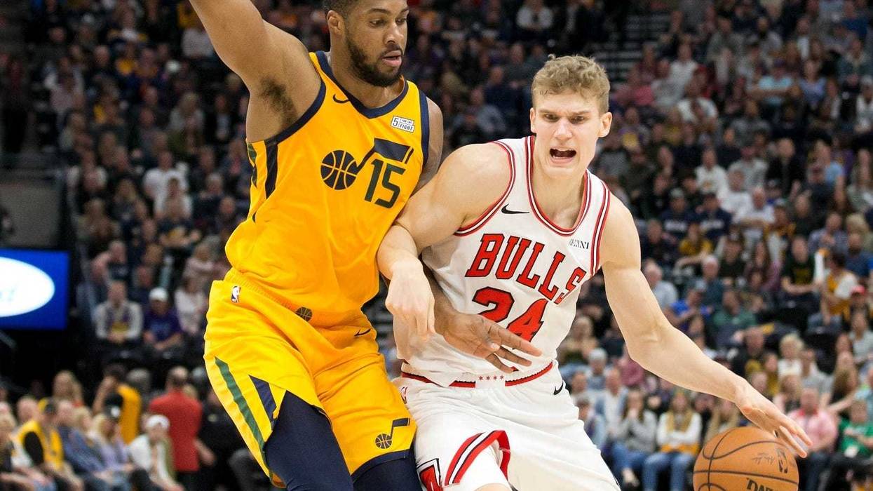 Bulls forward Lauri Markkanen (24) dribbles the ball as Jazz forward Derrick Favors (15) defends.
