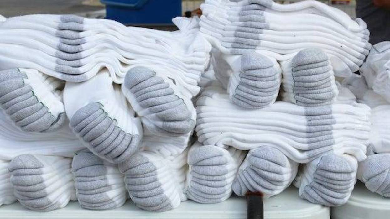 Bundles of white athletic crew socks on a table at an outdoor flea market