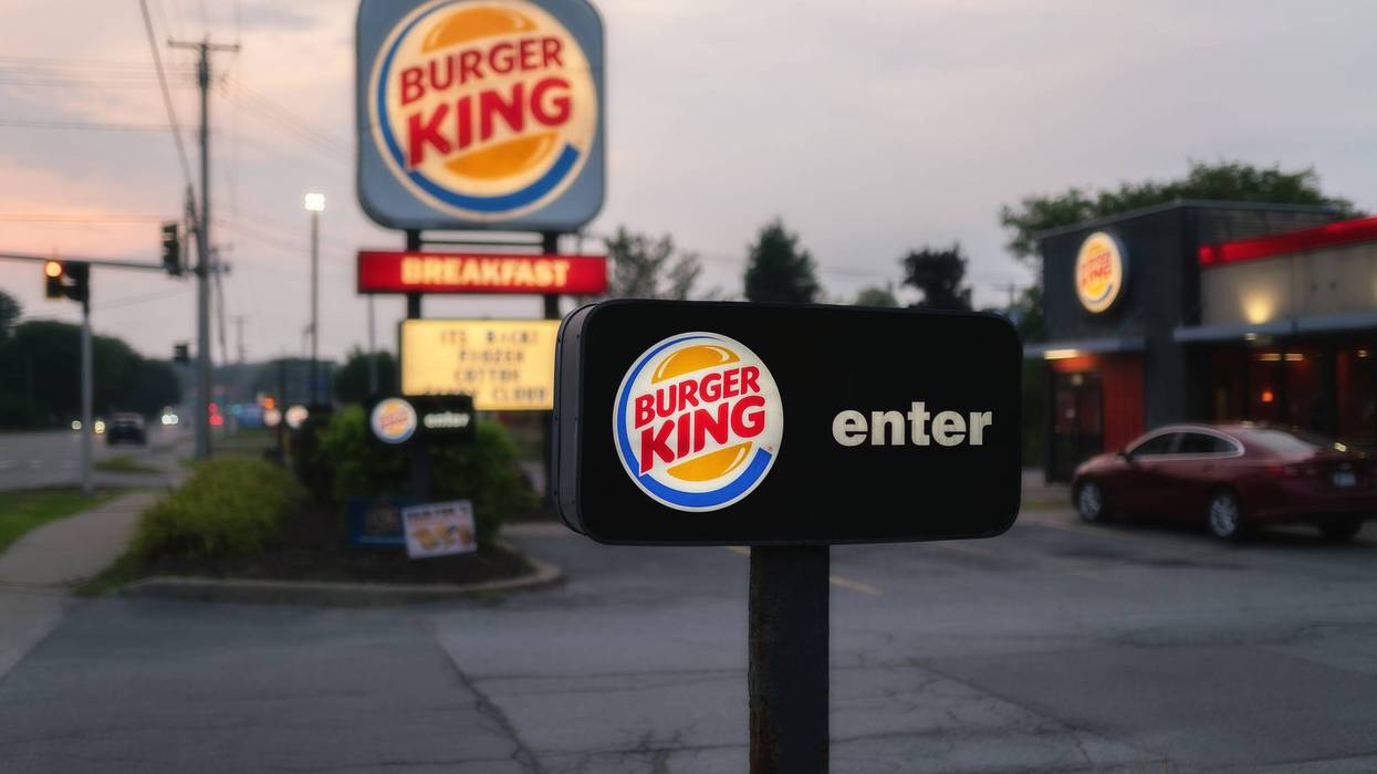 Burger King restaurant entrance at dusk, with illuminated signs including a large main sign and an 'enter' sign.