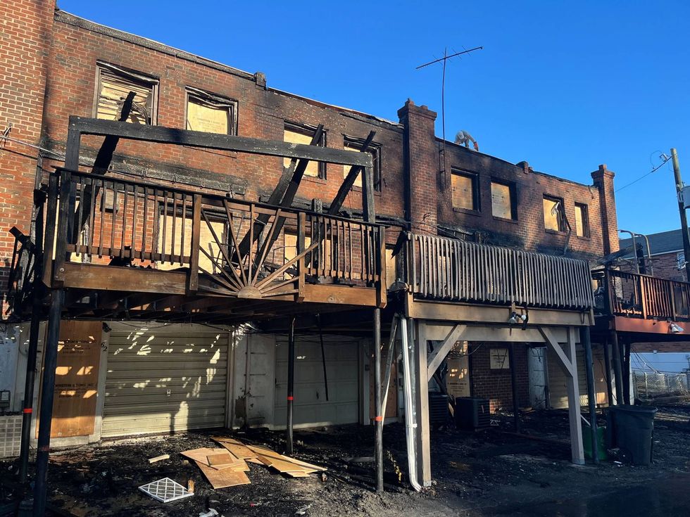 Burned out shells of homes are boarded up as neighbors in Folcroft, Delaware County, come together to get help to several families who have been displaced.