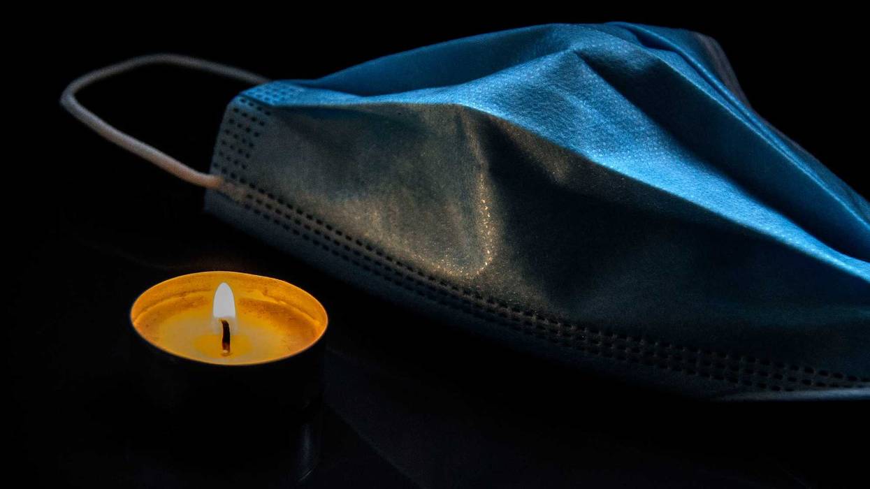 Burning candle and protective medical face mask