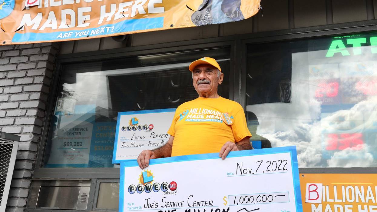 Business owner Joe Chahayed holds a Powerball bonus check outside Joe's Service Center that sold the winning Powerball ticket of $2.04 billion in Altadena, California on Nov. 8, 2022.