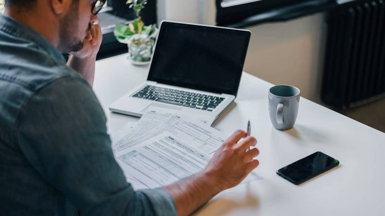 businessman or entrepreneur in office filing income tax return papers documents for IRS