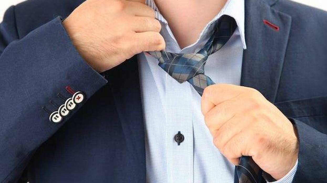 Businessman taking off necktie