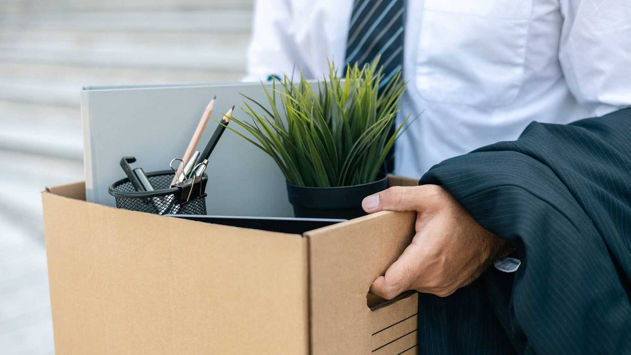 Businessman with box cardboard packing personal items after losing jobs. Failure businessman standing at front of building. Your fired Unemployed Jobless People Crisis