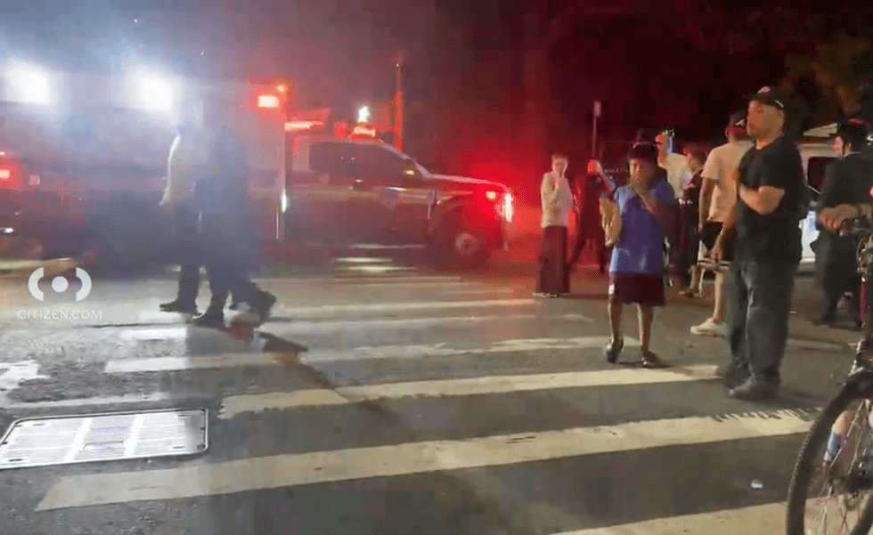 Bystanders watch the police response to the shooting on Sunday night