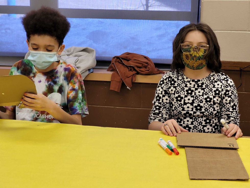 Cadon and his friend Hannah work on arts and crafts