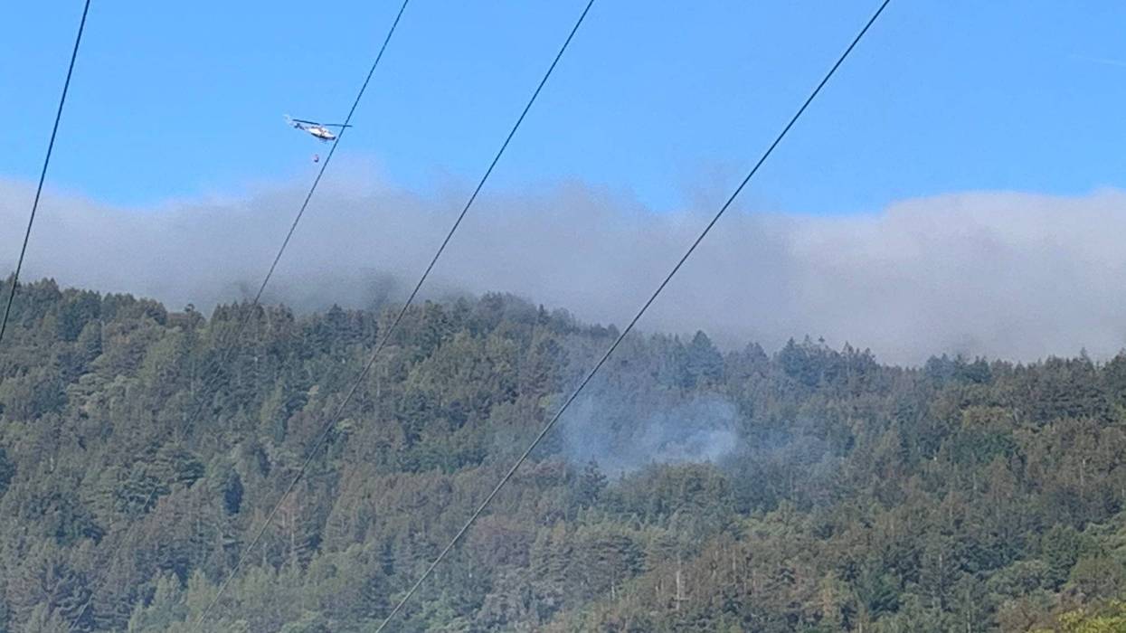 CAL FIRE helicopter drops water on the Canada Fire burning in Santa Cruz Mountains, May 14, 2021