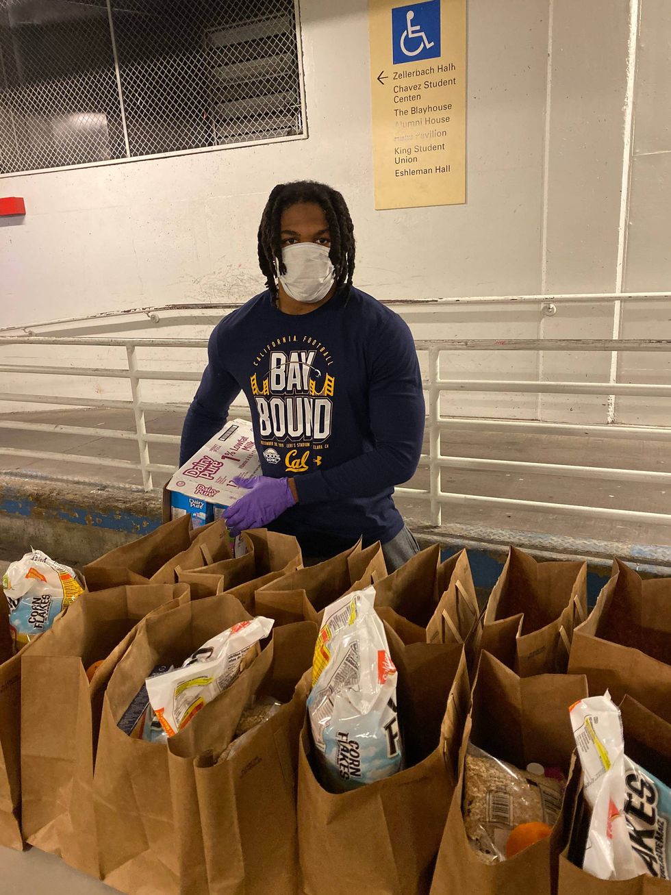 Cal football star Elijah Hicks helping at a food pantry.