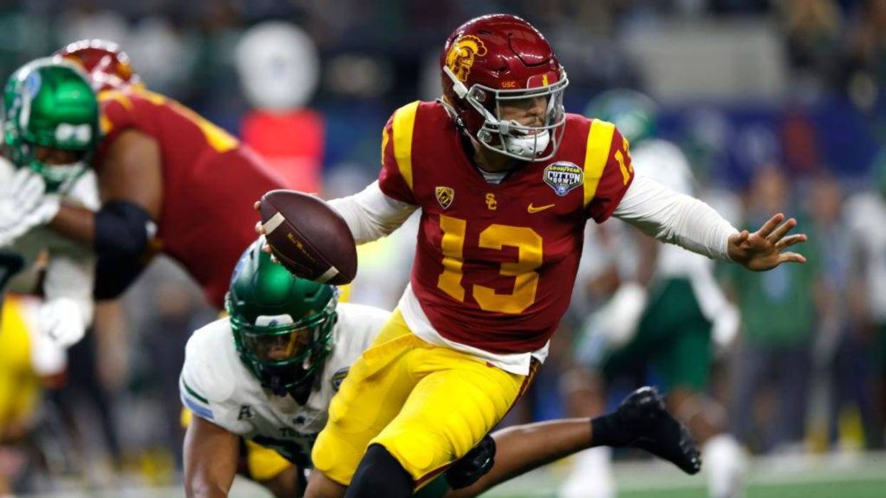 Caleb Williams #13 of the USC Trojans scrambles against the Tulane Green Wave in the first half of the Goodyear Cotton Bowl Classic on January 2, 2023 at AT&T Stadium in Arlington, Texas.