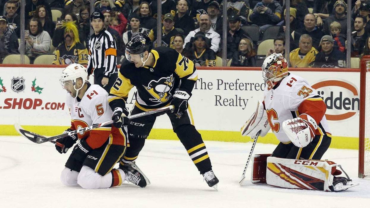 Calgary Flames defenseman Mark Giordano (5) and Pittsburgh Penguins right wing Patric Hornqvist (72) battle for the puck in front of Flames goaltender David Rittich (33) during the first period at PPG Paints Arena