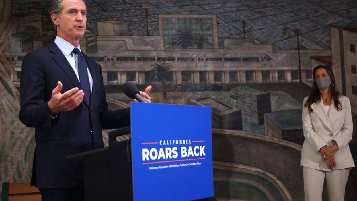 California Gov. Gavin Newsom (L) speaks during a press conference as Oakland Mayor Libby Schaff (R) looks on at The Unity Council on May 10, 2021 in Oakland, California.