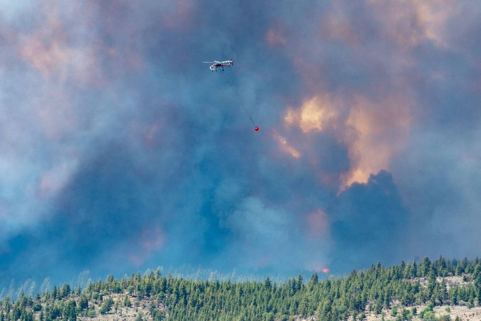 California Highway Patrolman and CalTrans employees provide road closure and safe entry and access for the firefighters and other resources in the area of the Beckwourth Complex Fire near Frenchman Lake in northern California, July 8, 2021.