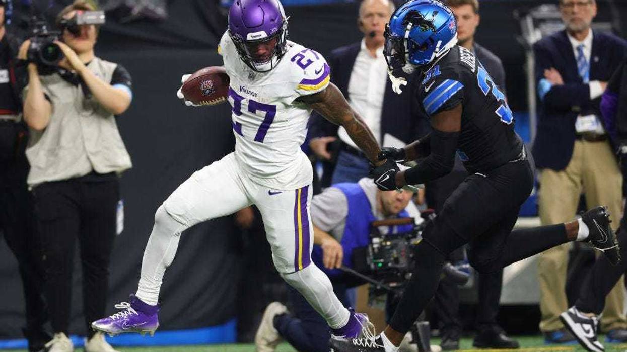 Cam Akers #27 of the Minnesota Vikings is tackled by Kerby Joseph #31 of the Detroit Lions during the third quarter at Ford Field on January 05, 2025 in Detroit, Michigan.