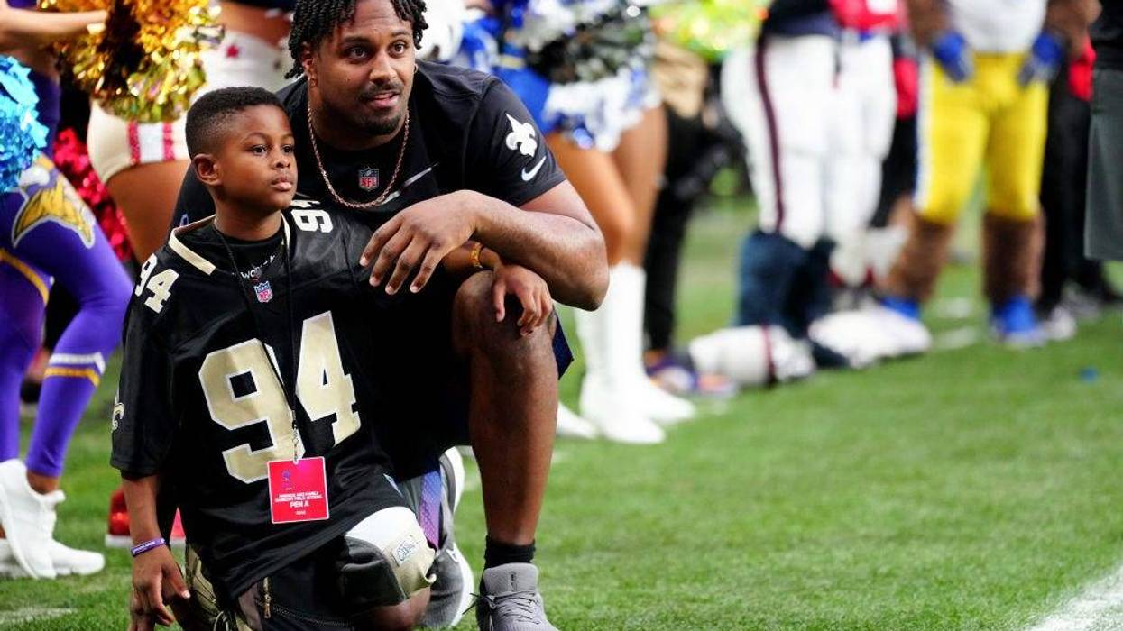 Cam Jordan with child in Saints jersey