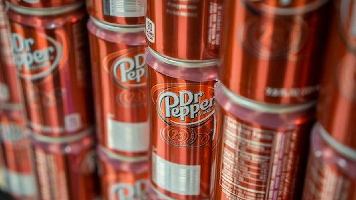 Cans of Dr. Pepper soda on a supermarket shelf