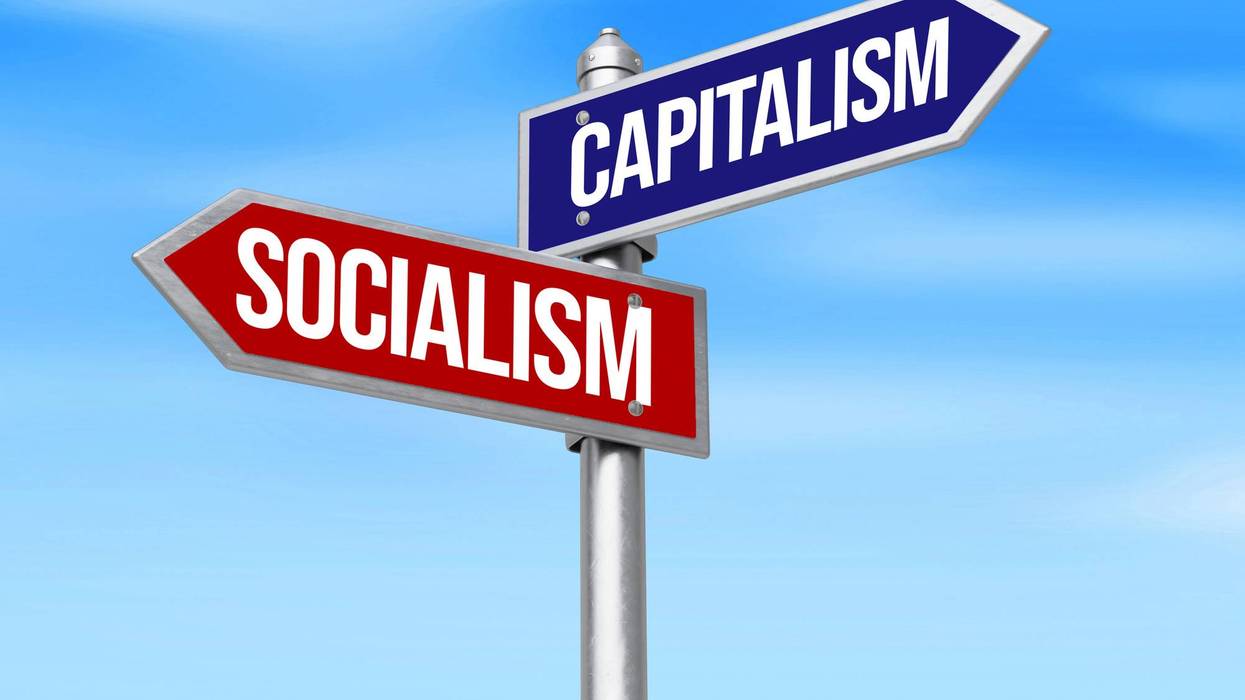 Capitalism vs Socialism on two signboards on is left and other is right, sky backdrop.