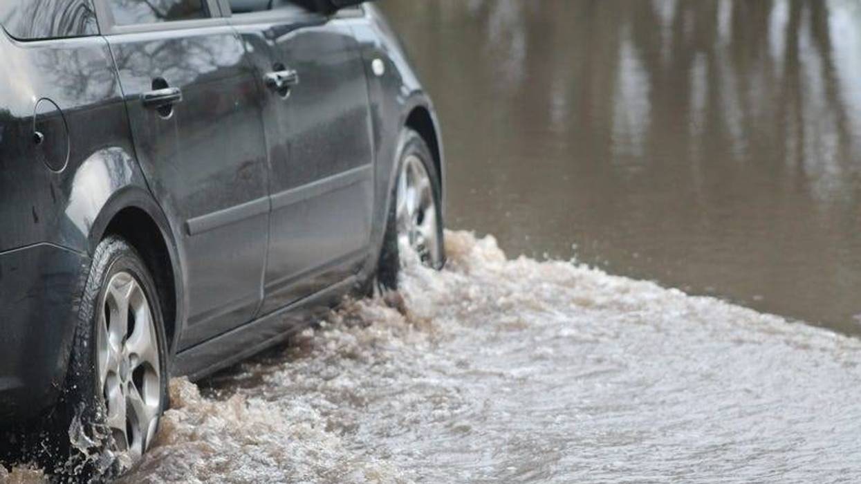 Car forcing a way through a flood on the River Ritec near Tenby, Pembrokeshire, UK