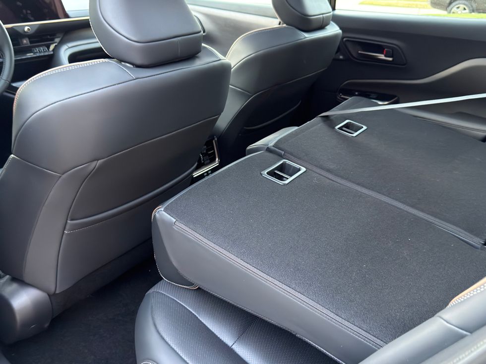 Car interior, black seats, with one rear seat folded down to create cargo space.