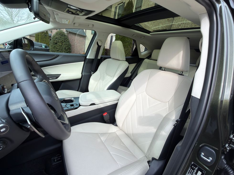 Car interior with white patterned leather seats, black trim, and panoramic sunroof.