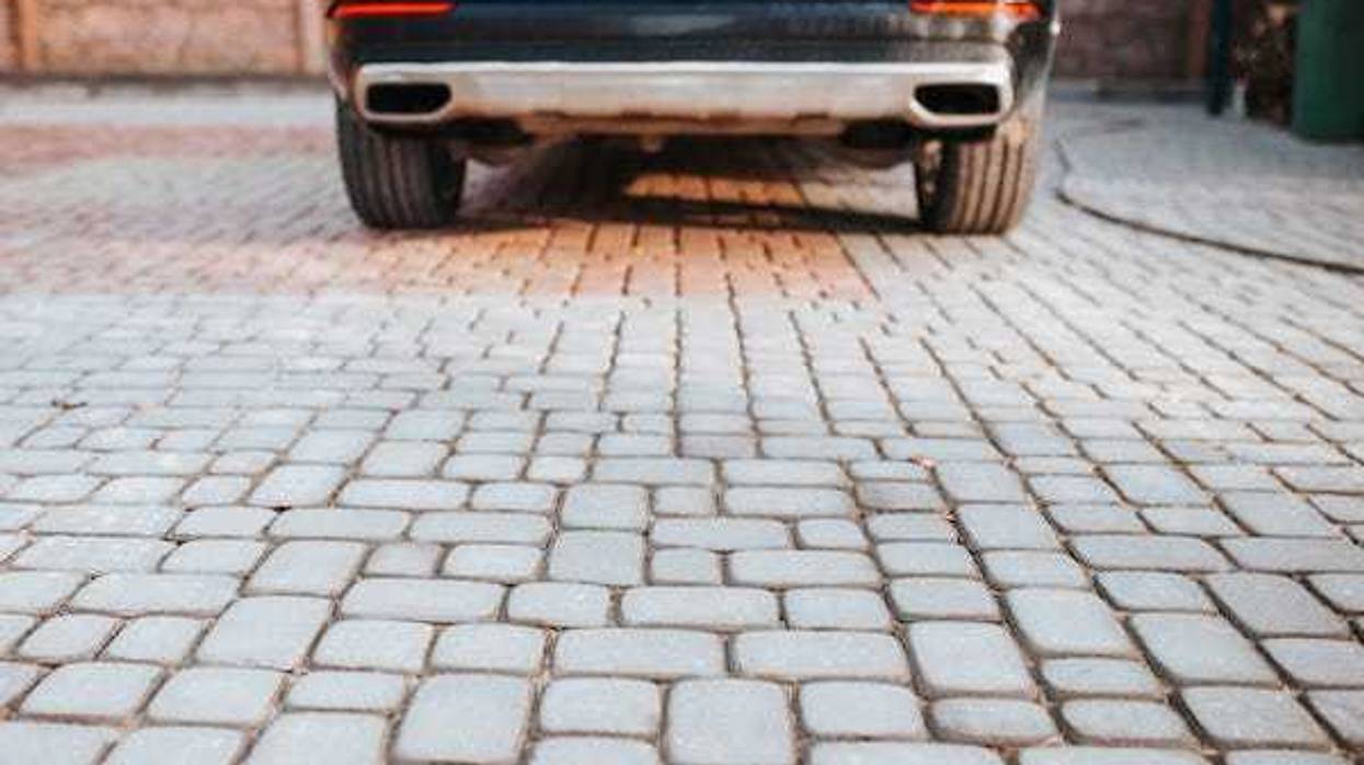 Car parked on cobblestone driveway