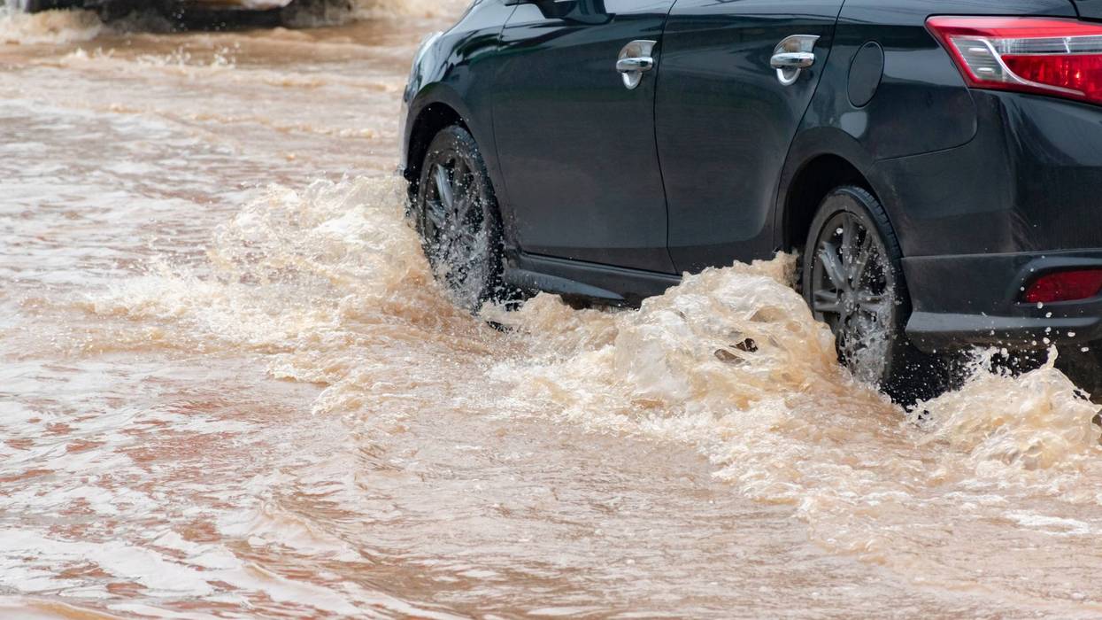 Car wheel in muddy rain and floodwater