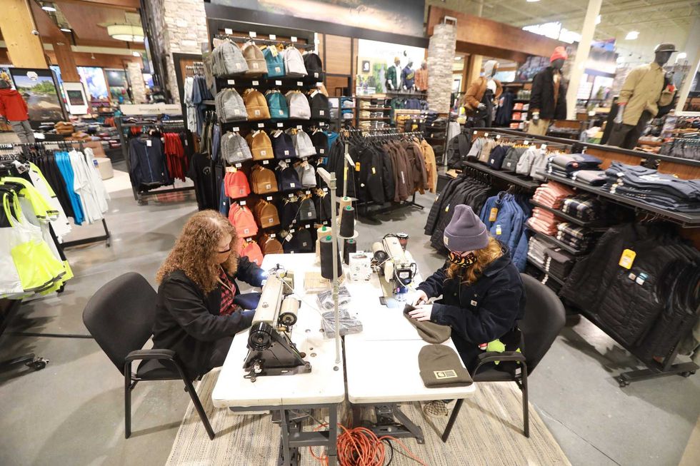Carhartt seamstresses Donya Dicken, left, and Shelby Stewart sew patches on hats as the Public Lands store opens at Polaris