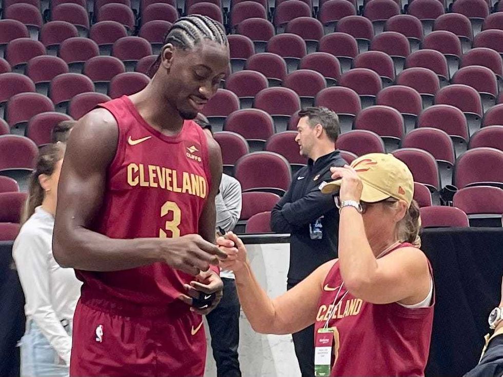 Caris LeVert (left) signs an autograph for a fan during Monday