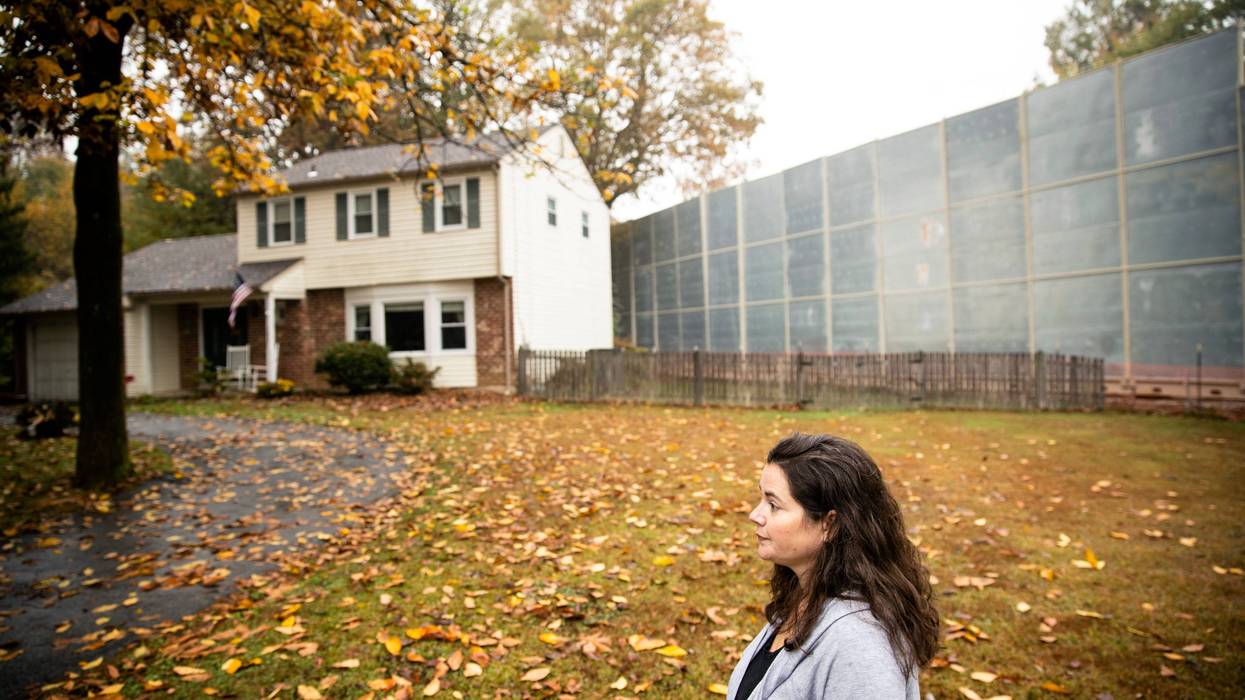 Carrie Gross walks past a construction barrier shielding the Mariner East pipeline near a home during an interview with The Associated Press in Exton, Pa.