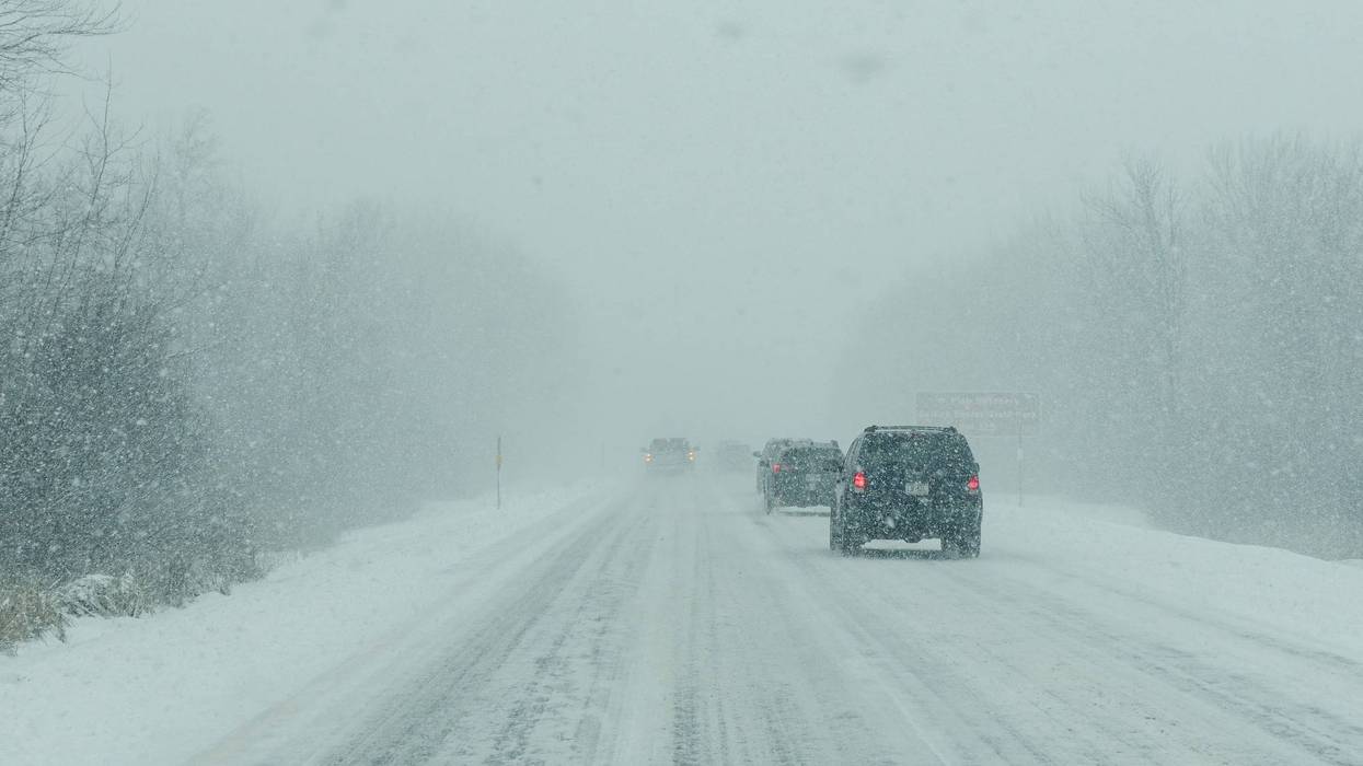 Cars driving along a highway as snow falls