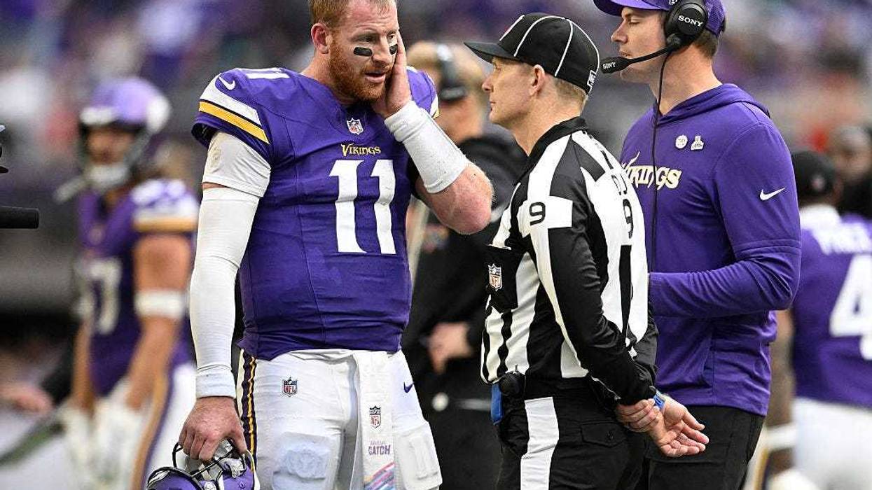 Carson Wentz #11 of the Minnesota Vikings talks with an official during the fourth quarter against the Philadelphia Eagles in the game at U.S. Bank Stadium on October 19, 2025 in Minneapolis, Minnesota.